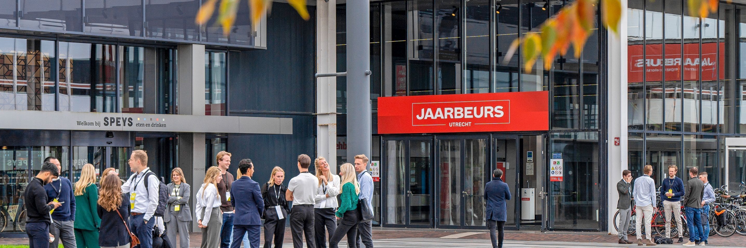 Groep mensen staan te praten voor het Jaarbeurs gebouw
