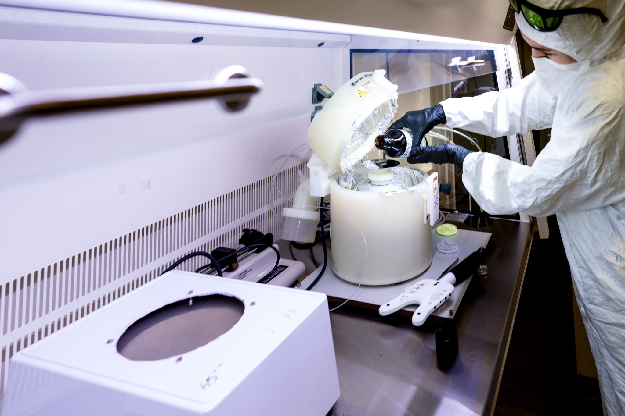 Geolab waar een persoon in labuniform een test doet 