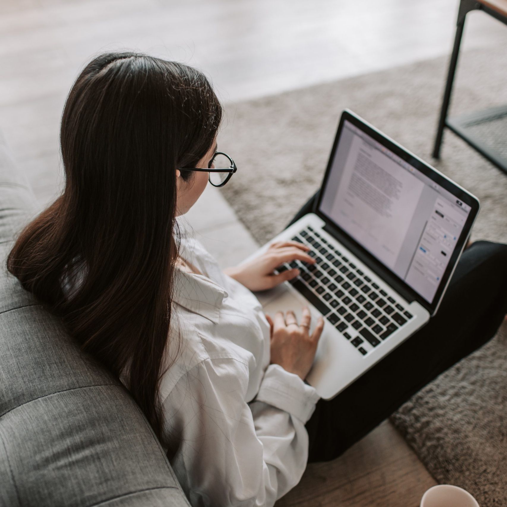 Vrouw met bril kijkend op een laptop